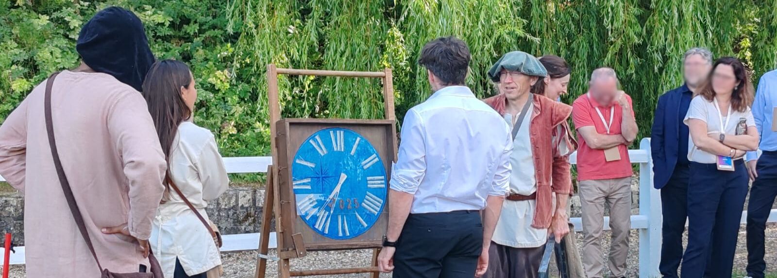 Un participant à l'orientescape 1587 est face à la machine à 
    remonter le temps d'AniméO sous l'oeil de ses collègues et entouré des acteurs.